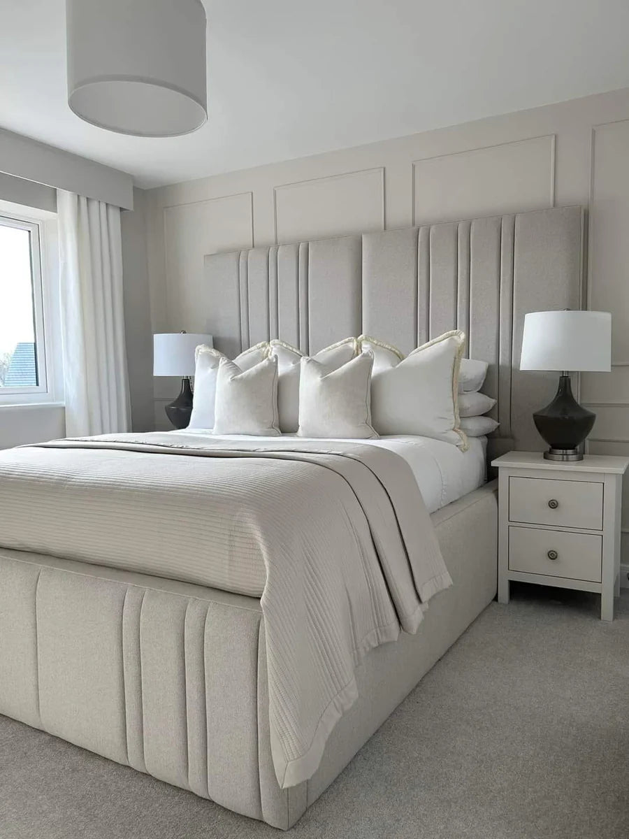 Modern bedroom with a large bed, headboard, and side tables.